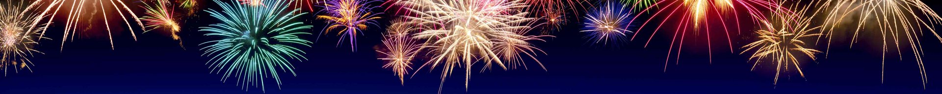 Farverige fyrværkerier eksploderer mod en mørkeblå baggrund. De lysegnistrende lys stråler i forskellige former og farver, hvilket skaber en festlig stemning, der ofte er forbundet med fejringer og specielle lejligheder.